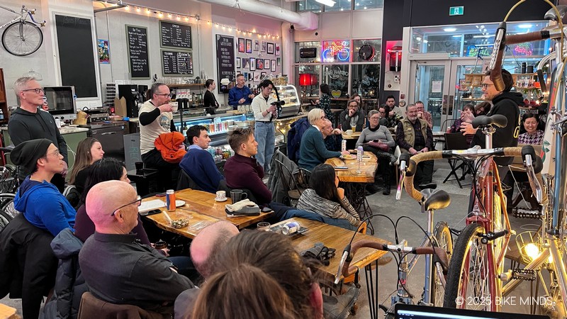 A group of people sitting in a cafe listening to a speaker at BIKE MINDS.
