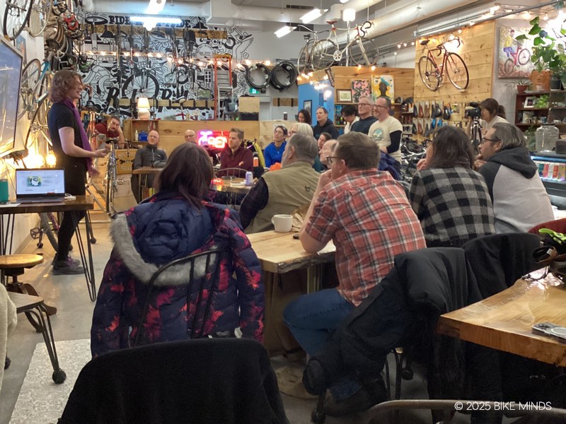 A group of people sitting in a cafe listening to a speaker at BIKE MINDS.