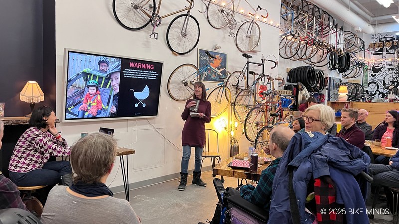 A group of people sitting in a cafe listening to a speaker at BIKE MINDS.